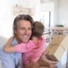 Father embracing son while receiving gift in living room